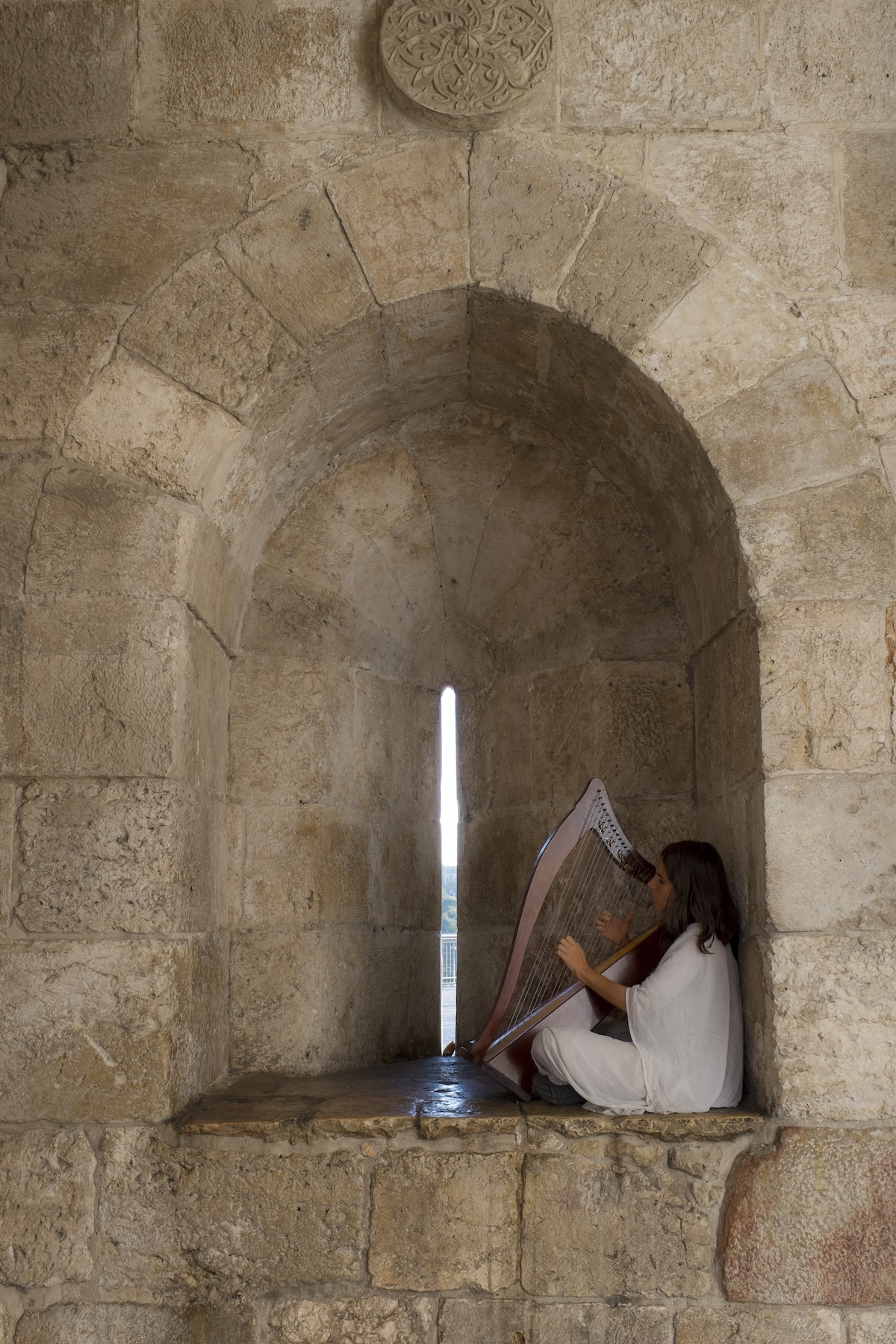 Woman plays harp at the Jaffa Gate in the Old City of Jerusalem on a photo tour