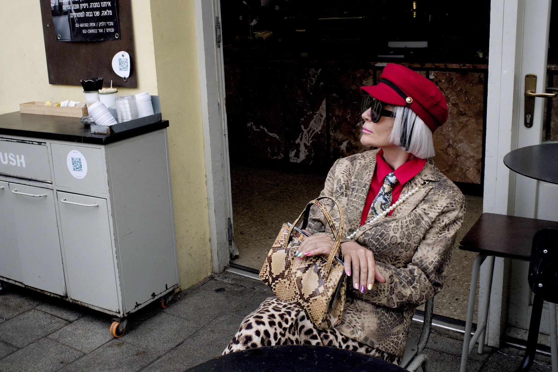 Stylish woman sits in a Tel Aviv coffee shop during a photography workshop
